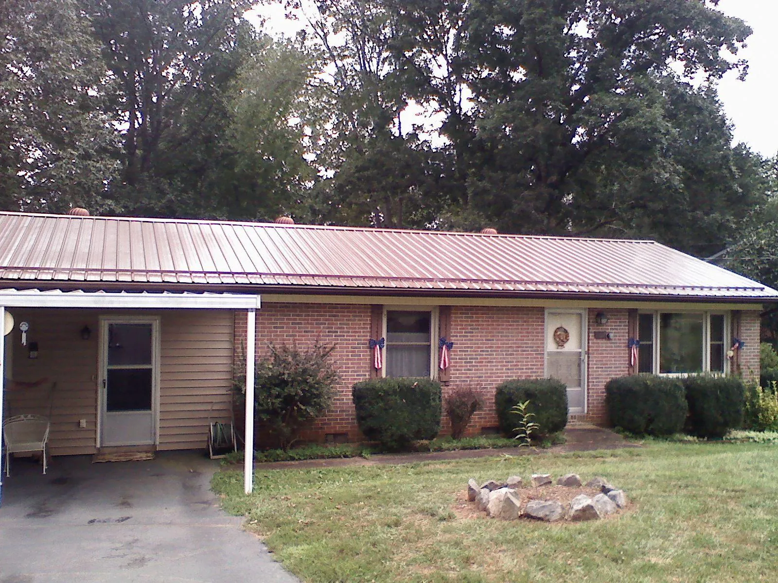 Bronze metal roof and carport on a brick ranch home — Roof Repair work by our crew in Plantersville